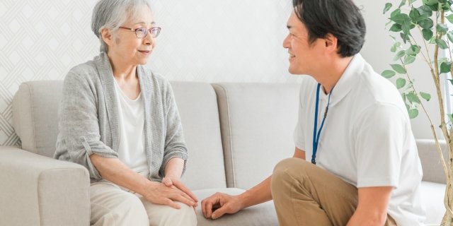 ご自宅のソファで利用者様と向き合う訪問看護師