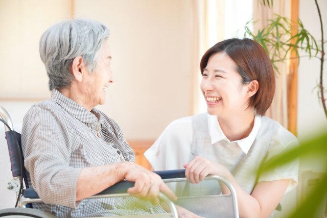 車いすの利用者様と笑顔で話すスタッフ